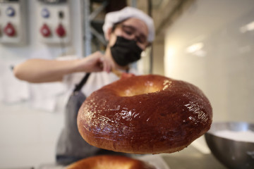 Archivo - Una empleada decora un roscón de Reyes, en la pastelería La Magdalena de Proust, 29 de diciembre de 2021, en Madrid, (España). Las fiestas navideñas ponen su fin con la llegada de los Re