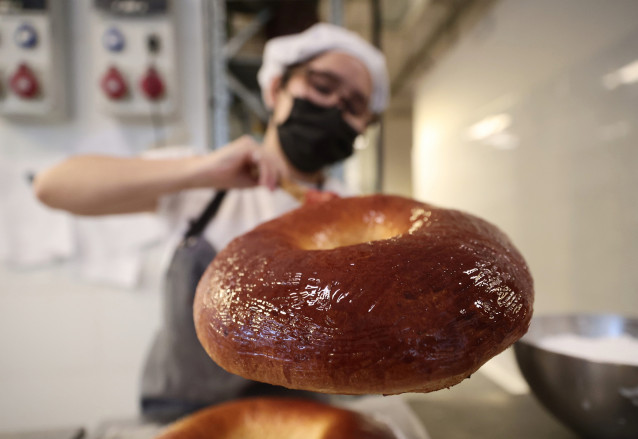 Archivo - Una empleada decora un roscón de Reyes, en la pastelería La Magdalena de Proust, 29 de diciembre de 2021, en Madrid, (España). Las fiestas navideñas ponen su fin con la llegada de los Reyes Magos, que además de venir cargados de regalos o de car