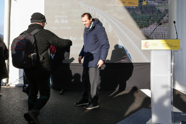 Entregan una camiseta de 'Altri non' al ministro de Transportes, Óscar Puente, en la inauguración del tramo Melide-Palas, en la autovía Santiago-Lugo