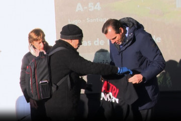 Activista entrega camiseta de Altri Non a Oscar Puente en la inaguración de la autovía en Palas