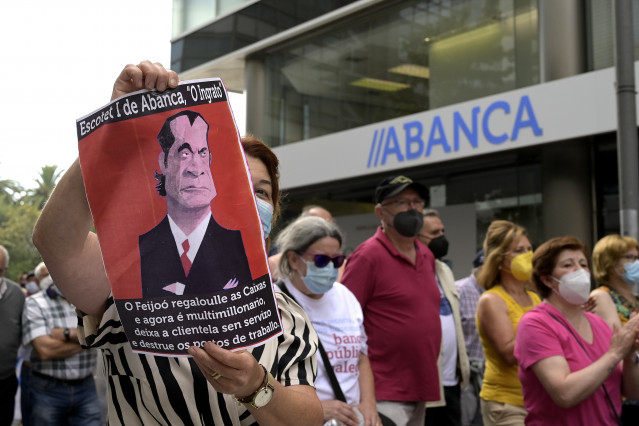 Archivo - Una persona sostiene una pancarta durante la manifestación contra el cierre de oficinas de la entidad Abanca ante la sede de Abanca en A Coruña, a 2 de septiembre de 2021, en A Coruña, Galicia, (España). El objetivo de la protesta, convocada por