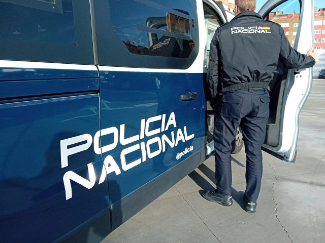 Archivo - Un agente y un coche de la Policía Nacional.