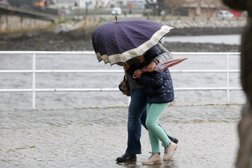 Archivo - Dos personas caminan con dificultad por el viento en Viveiro, a 8 de enero de 2025, en Viveiro, Lugo, Galicia (España). Durante esta mañana de miércoles, Galicia ha registrado vientos de 