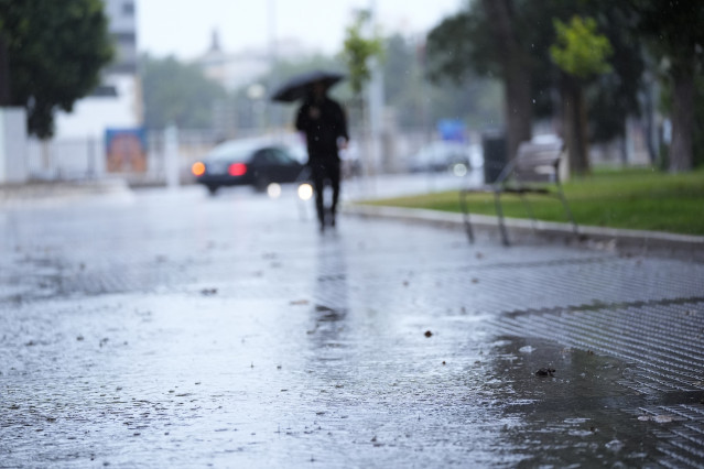 Archivo - Transeuntes bajo sus paraguas durante la intensa lluvia.