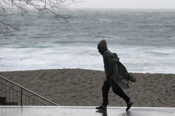 Archivo - Una persona camina por el paseo marítimo de A Coruña, Galicia (España), a 30 de enero de 2021. Este sábado Galicia está afectada por una borrasca denominada 'Justine' que ha dejado ciel