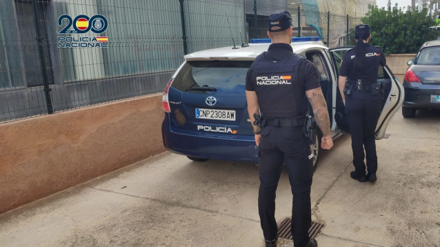 Archivo - Agentes de la Policía Nacional frente a un coche patrulla.