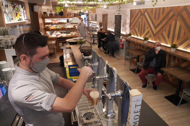 Archivo - Un camarero llena un vaso de cerveza en un restaurante durante el primer día de la apertura parcial de la hostelería en Santiago de Compostela, A Coruña, Galicia (España), a 26 de febrero de 2021. La Xunta de Galicia reabre desde hoy parcialment