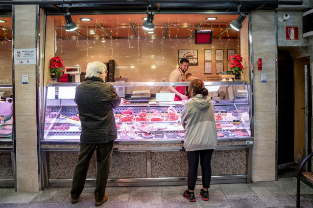 Archivo - Varias personas hacen compras de última hora en un mercado.