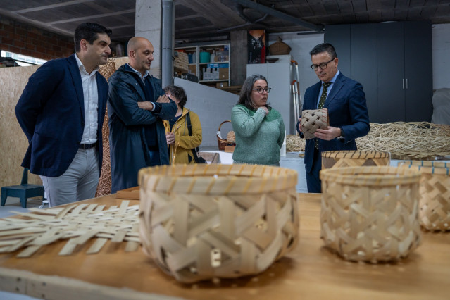 El conselleiro de Emprego, Comercio e Emigración, José González; el director xeral de Comercio, Gabriel Alén; y el alcalde de O Porriño, Alejandro Lorenzo, visitan el taller La Parabólica, de la artesana cestera Julia de la Cal.